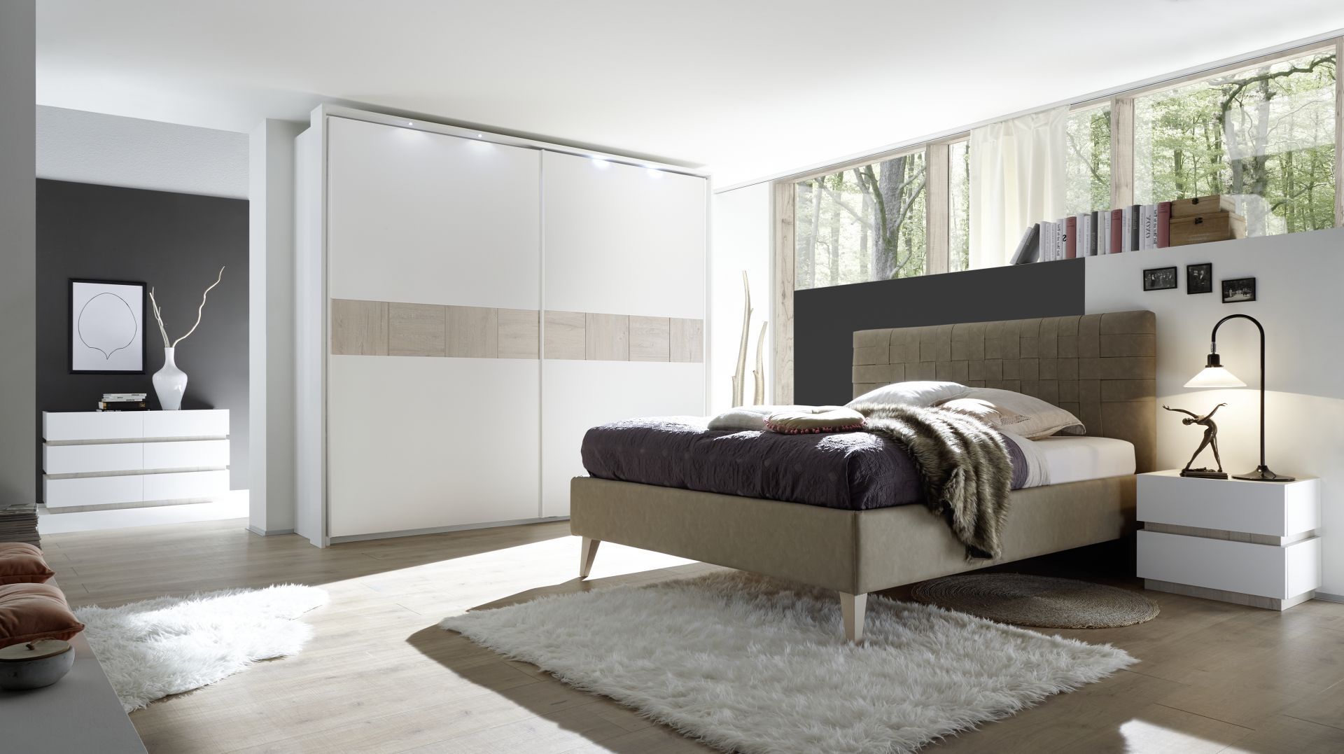 Camera da letto moderna con grande armadio scorrevole bianco e letto imbottito color tortora