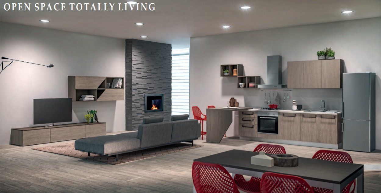 Ambiente open space con zona living grigia, parete attrezzata a mensole e cucina moderna sul fondo